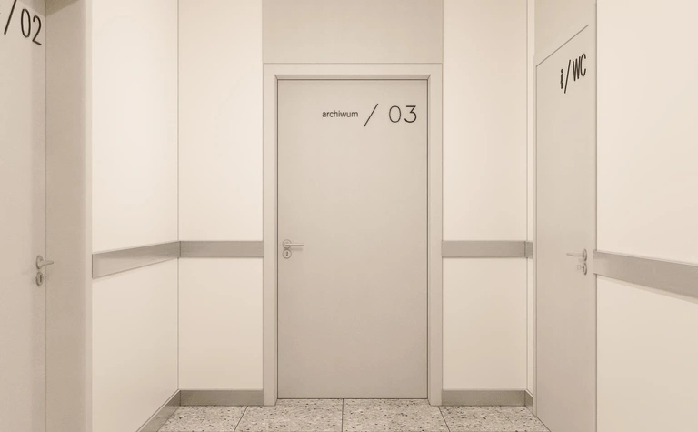 Korytarz w minimalistycznym stylu z szarymi ścianami i nowoczesnymi drzwiami.