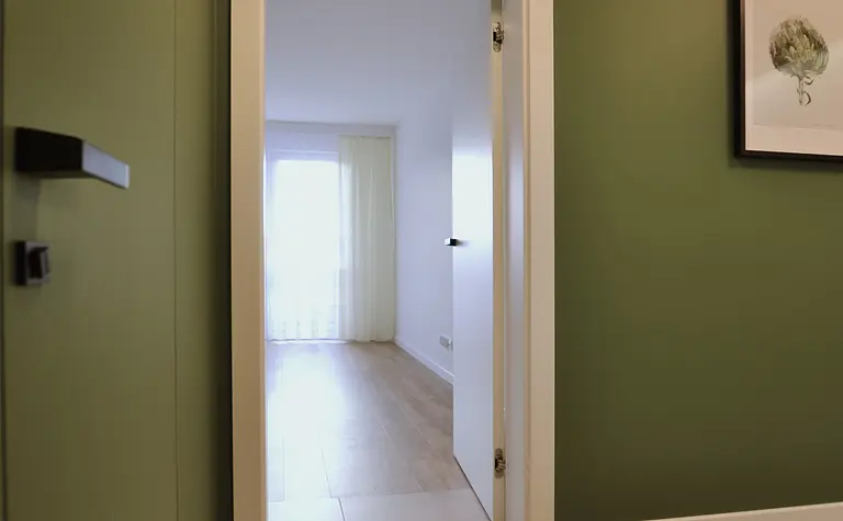 Przedpokój w stylu minimalistycznym i skandynawskim z zielonymi ścianami.