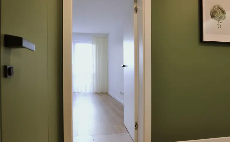 Przedpokój w stylu minimalistycznym i skandynawskim z zielonymi ścianami.