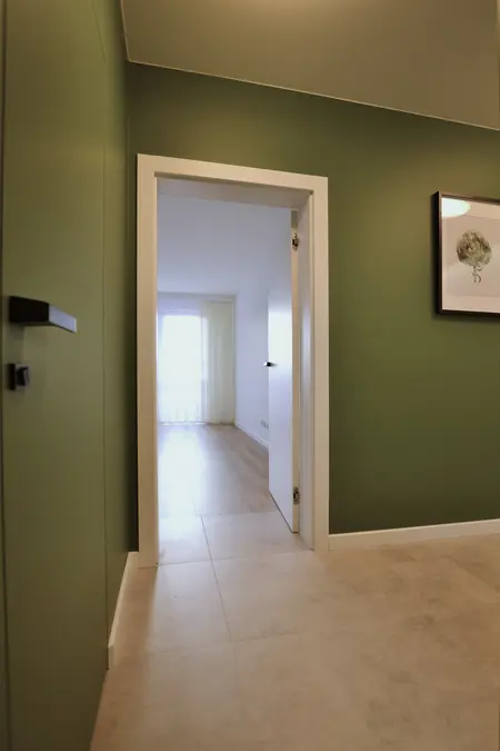 Przedpokój w stylu minimalistycznym i skandynawskim z zielonymi ścianami.