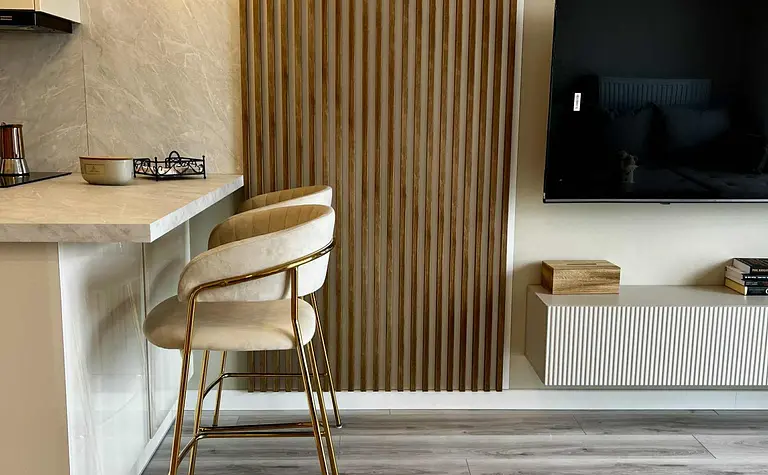 Wnętrze kuchni z drewnianą ścianą i minimalistycznym stylem glamour.