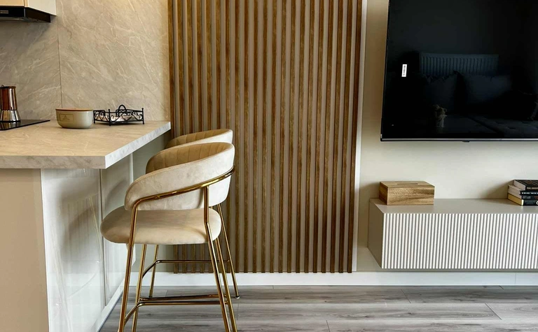 Wnętrze kuchni z drewnianą ścianą i minimalistycznym stylem glamour.