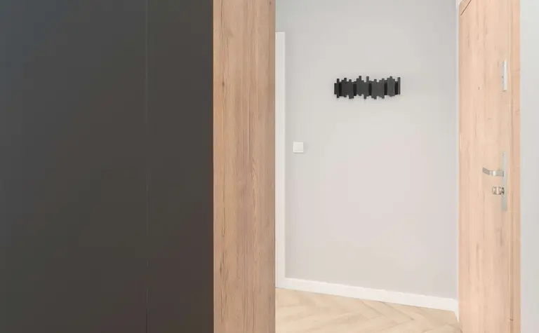 Korytarz w stylu industrialnym z drewnianymi ścianami i czarnymi detalami