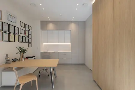 Wnętrze biura w stylu japandi i minimalistycznym z szarymi meblami.
