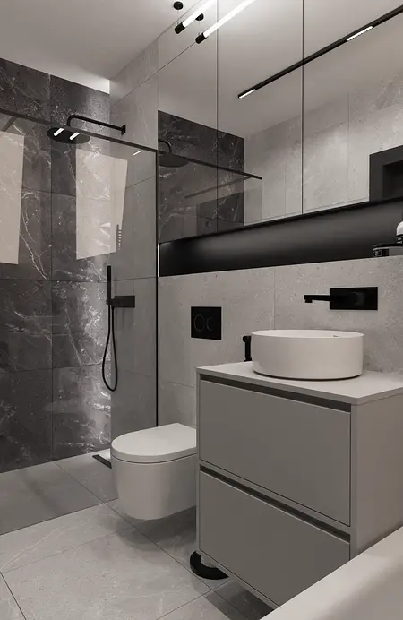 Minimalistyczna łazienka z szarymi płytkami i białą umywalką, nowoczesne oświetlenie.