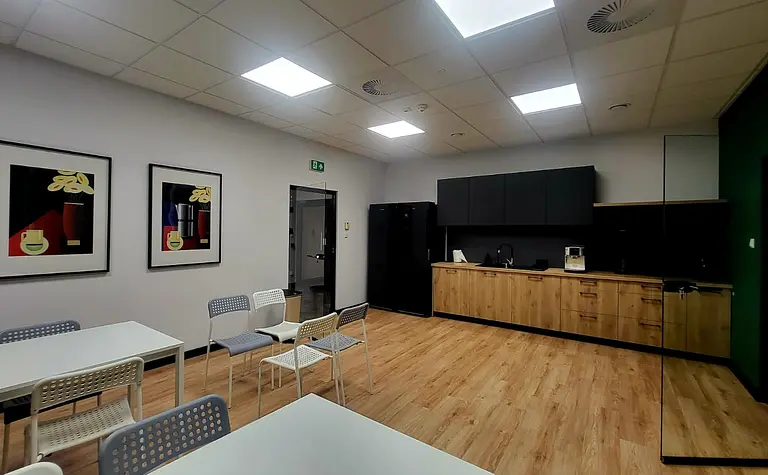 Wnętrze kuchni z czarnymi meblami i drewnianą podłogą, nowoczesny styl