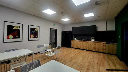 Wnętrze kuchni z czarnymi meblami i drewnianą podłogą, nowoczesny styl