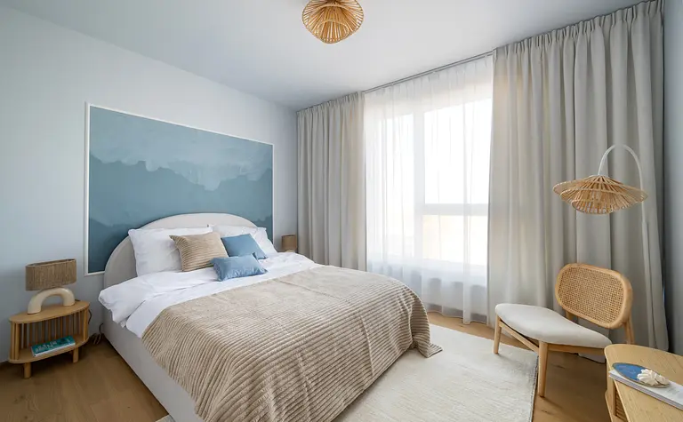 Sypialnia w stylu skandynawskim z niebieską ścianą i jasnym łóżkiem