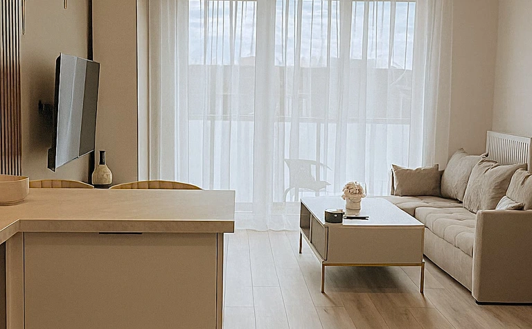 Glamour minimalistyczny salon z jasnymi meblami i dużymi oknami
