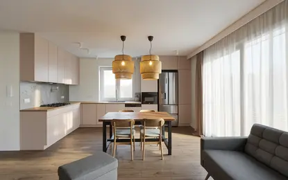 Wnętrze kuchni z minimalistycznym designem, różowe meble i drewniany stół.