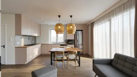 Wnętrze kuchni z minimalistycznym designem, różowe meble i drewniany stół.