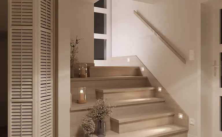 Minimalistyczna klatka schodowa z drewnianymi schodami i dekoracjami.