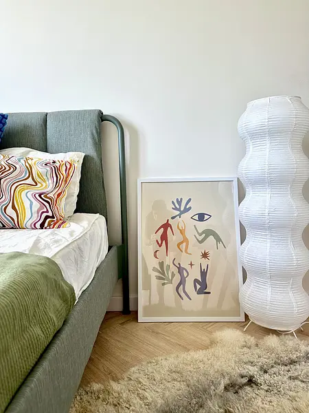 Sypialnia z łóżkiem, lampą i kolorowymi poduszkami w stylach boho, eklektycznym i skandynawskim.