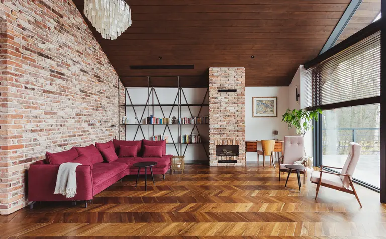 Wnętrze salonu w stylu dopamine decor, industrialnym i rustykalnym z ceglaną ścianą.
