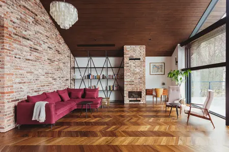 Wnętrze salonu w stylu dopamine decor, industrialnym i rustykalnym z ceglaną ścianą.
