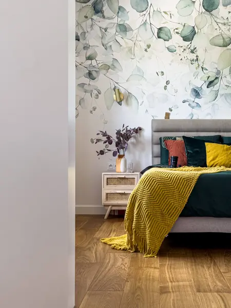 Sypialnia w stylu minimaluxe z zielonymi poduszkami i drewnianą podłogą