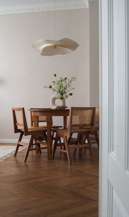 Wnętrze jadalni w stylu japandi z drewnianym stołem i nowoczesnymi krzesłami.