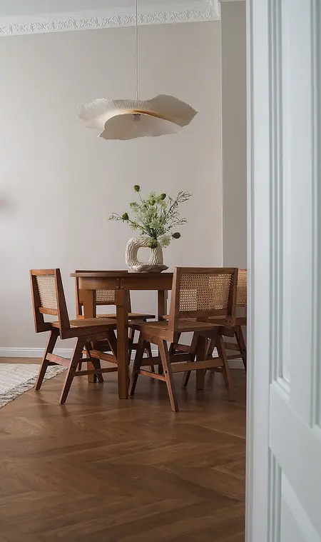 Wnętrze jadalni w stylu japandi z drewnianym stołem i nowoczesnymi krzesłami.