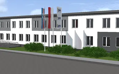 Widok budynku z szaro-białą elewacją i zielonymi krzewami, styl industrialny i nowoczesny.