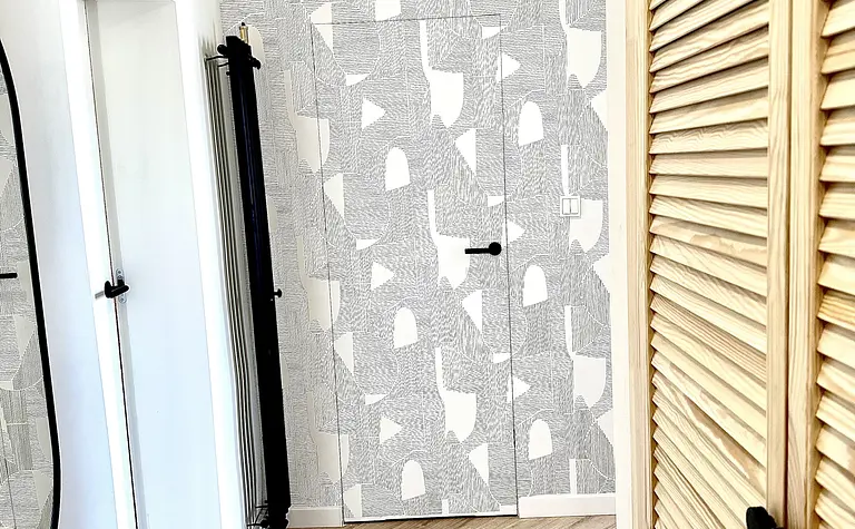 Przedpokój w stylu boho, eklektycznym i skandynawskim z drewnianą podłogą i szarymi ścianami.