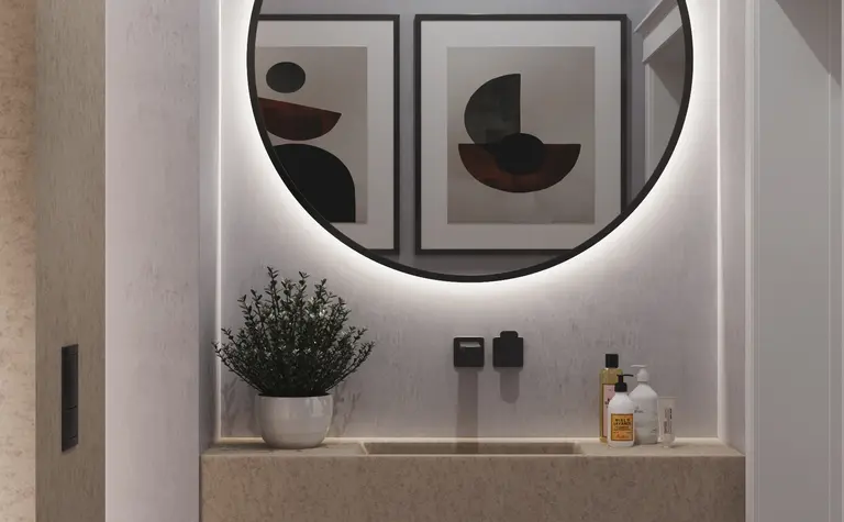 Minimalistyczna toaleta z okrągłym lustrem i nowoczesnym blatem. Wnętrze w stylu quiet luxury.