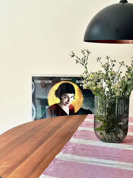 Wnętrze jadalni w stylu boho, skandynawskim i eklektycznym z drewnianym stołem i kwiatami.