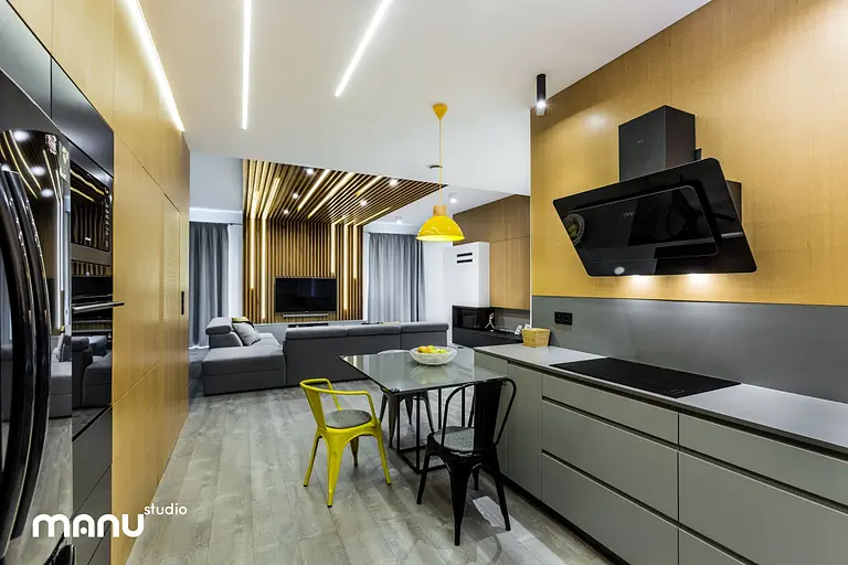 Wnętrze kuchni w stylu industrialnym i skandynawskim z drewnianymi detalami i nowoczesnym oświetleniem.