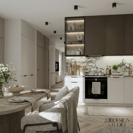 Wnętrze kuchni z marmurowym blatem, drewnianym stołem oraz nowoczesnym designem w stylu quiet luxury.