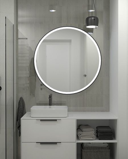 Minimalistyczna łazienka z okrągłym lustrem, białą umywalką i szarymi akcentami.