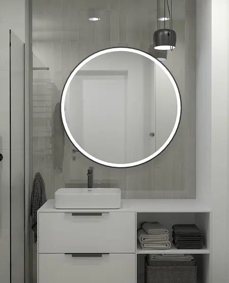 Minimalistyczna łazienka z okrągłym lustrem, białą umywalką i szarymi akcentami.