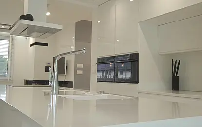 Nowoczesna kuchnia minimalistyczna z białymi meblami i akcentami szarości